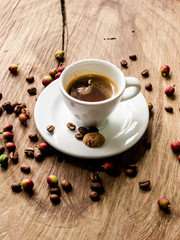 coffee beans behind cup of black coffee