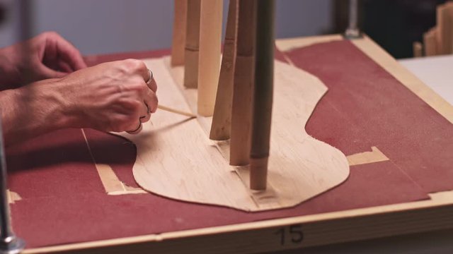 Professional guitar maker making an acoustic guitar body