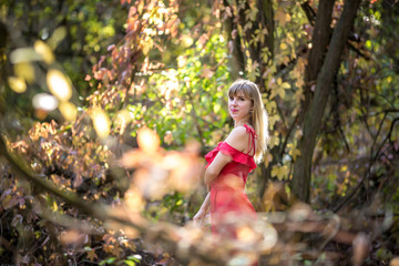 Beautiful elf girl in red dress in the autumn forest. forest fantasy fairy tale