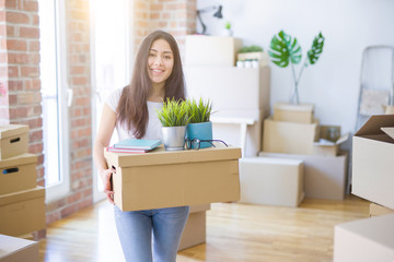 Young beautiful woman moving cardboard boxes at new home