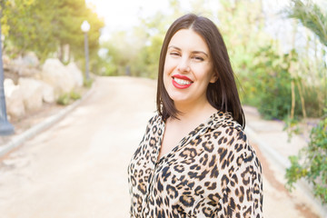 Young beautiful woman with red lips smiling happy at garden