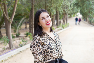 Young beautiful woman with red lips smiling happy at garden