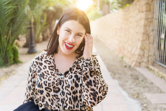 Young beautiful woman with red lips smiling happy at garden