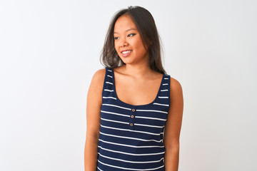 Obraz premium Young chinese woman wearing striped t-shirt standing over isolated white background looking away to side with smile on face, natural expression. Laughing confident.
