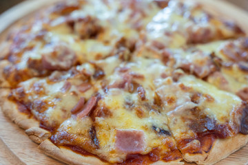 Hot pizza slice with dripping ham sausage and mozzarella cheese.