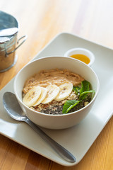 Breakfast oatmeal with peanut butter, banana slices, chia seeds and honey