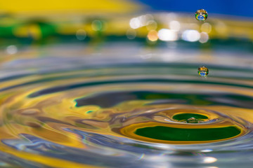 water droplet splash with brazil flag colors, blue, white isolated on white background. Brazil flag reflection in water drop