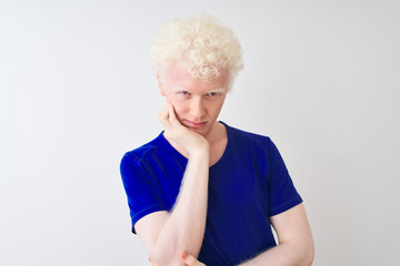 Young albino blond man wearing blue casual t-shirt standing over isolated white background thinking looking tired and bored with depression problems with crossed arms.