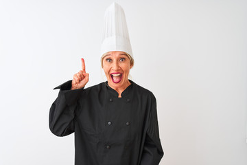 Middle age chef woman wearing uniform and hat standing over isolated white background pointing finger up with successful idea. Exited and happy. Number one.