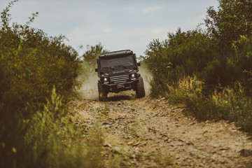 Motion the wheels tires and off-road that goes in the dust on the sand. Off-road travel on mountain road. Expedition offroader. Tracks on a muddy field. Road adventure. Adventure travel. © Volodymyr