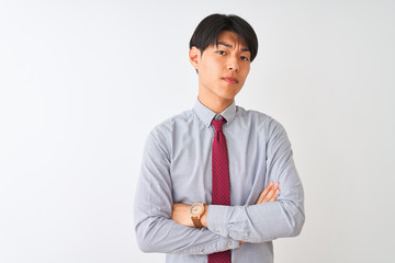 Chinese businessman wearing elegant tie standing over isolated white background skeptic and nervous, disapproving expression on face with crossed arms. Negative person.