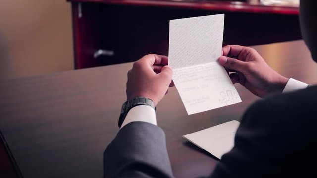 Groom Reading and Holding Vow Cards