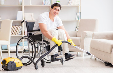Fototapeta na wymiar Disabled man with vacuum cleaner at home