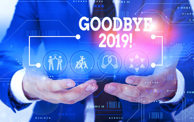 Conceptual hand writing showing Goodbye 2019. Concept meaning express good wishes when parting or at the end of last year Male wear formal suit presenting presentation smart device