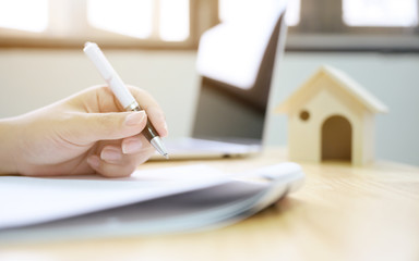 Fototapeta premium Close up hand of man signing signature loan document to home ownership. Mortgage and real estate property investment