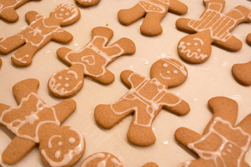Gingerbread man cookies freshly made at home, just decorated with white icing in a funny and happy style. Great for making with the kids as a family near the Christmas and winter holidays.