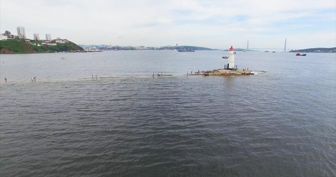 Aerial view of Tokarevsky lighthouse in Vladivostok and tourists came here to take pictures of nice landscape. Russian bridge is on the background. Summer