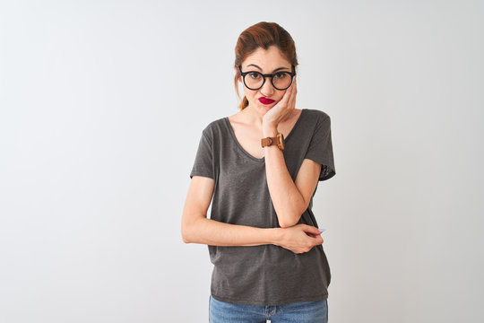Redhead woman wearing casual t-shirt and glasses standing over isolated white background thinking looking tired and bored with depression problems with crossed arms.