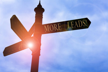 Handwriting text writing More Leads. Conceptual photo initiation consumer interest enquiry into products or services Road sign on the crossroads with blue cloudy sky in the background © Zofia