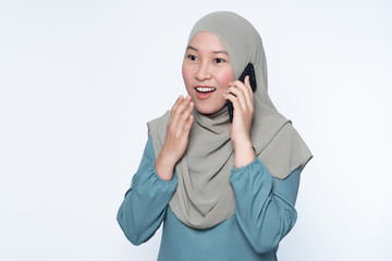 Beautiful muslim woman talking on her mobile phone with surprise expression