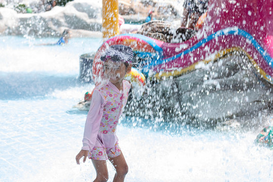 Little girls is playing in the aquapark on a summer holiday.