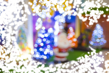 Spray snow through glass background with santa claus blur background