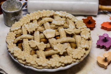 Selective Focus Closeup of a decorative unbaked pie crust with braids and autumn leaves