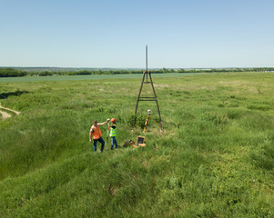 Man and Woman land surveyors a construction site. Young engineers surveyor in helmets give each other five. ..