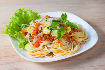Spaghetti pasta with minced pork on wood background