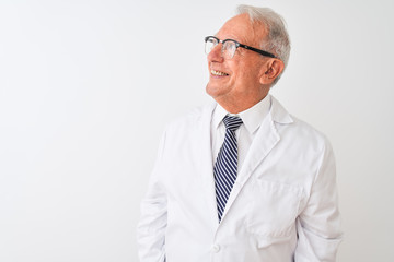 Senior grey-haired scientist man wearing coat standing over isolated white background looking away...