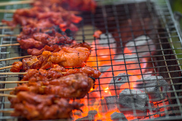 The blurred background of grilling chicken on a charcoal grill, with the heat of the flame from the oil of the meat, spreading smoke and a fragrant flavor from the food smell.