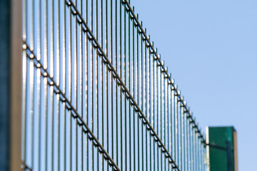 Metal grill against the blue sky.