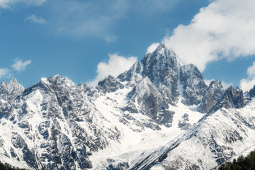 Fototapeta na wymiar Panoramic snow mountain with white clouds and blue sky