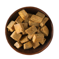 Pieces of fried tofu cheese in a clay bowl isolated on a white background.