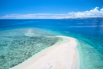 Woman on remote island in Fiji overlooking blue coral reef	