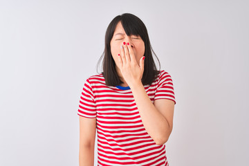 Young beautiful chinese woman wearing red striped t-shirt over isolated white background bored yawning tired covering mouth with hand. Restless and sleepiness.