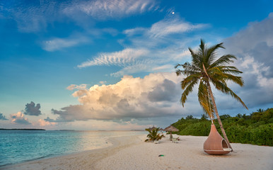 Exotic tropical beach background as summer landscape with cocoon beach swing and white sand and turquoise  calm sea. Perfect sunset beach scene for vacation and summer holiday concept.