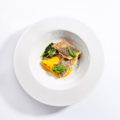 Cod fillet with pumpkin puree and spinach top view