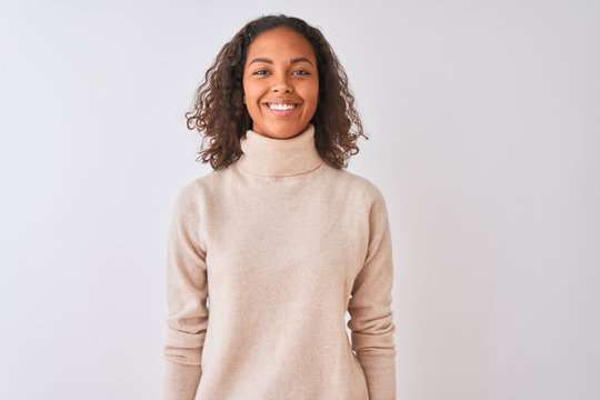 Young brazilian woman wearing turtleneck sweater standing over isolated white background with a happy and cool smile on face. Lucky person.