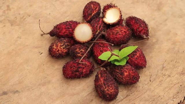 Lychee with leaves isolated on wood background.