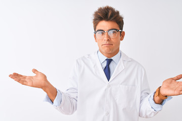 Young handsome sciencist man wearing glasses and coat over isolated white background clueless and confused expression with arms and hands raised. Doubt concept.