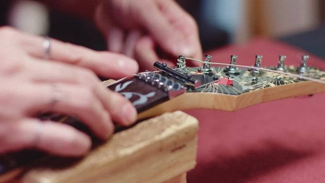 Guitarist wrap string with peg