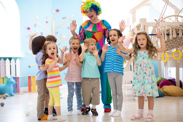 Clown and children group playing indoor . Holiday in a children's club. Games with animator