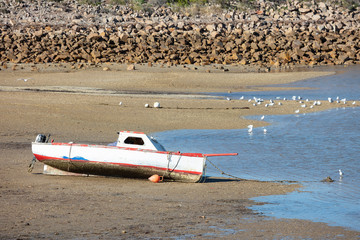Small red fishing boat beached at Port Augusta, South Australia