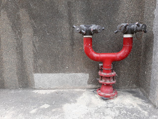 red fire hydrant on gray concrete wall