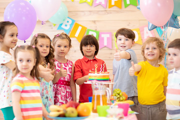 Group of preschool children celebrating birthday party together in kindergarten