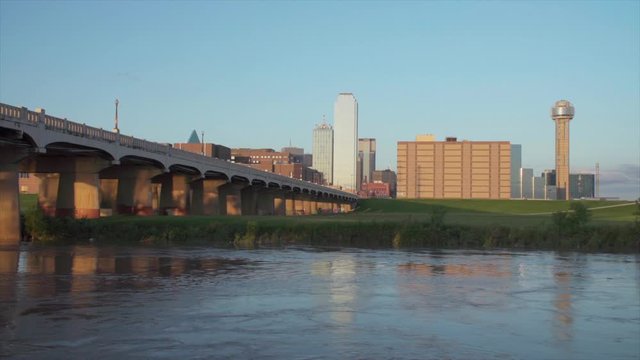 Dallas Skyline with the Trinity River in the foreground during sunset. - Slow moving water - 1080p