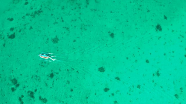 Tourist motor boat on the surface of turquoise water in tropical lagoon, aerial view. boat trip