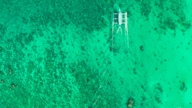 Tourist motor boat on the surface of turquoise water in tropical lagoon, aerial view. boat trip