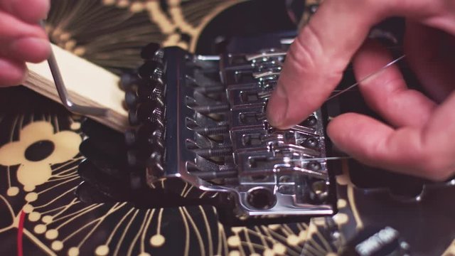 Guitar maker fix strings on the bridge